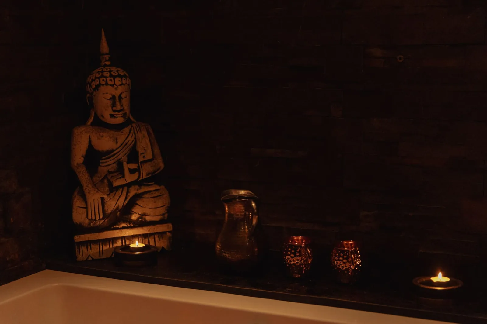 Stone Buddha and candles beside the hot tub at Sensation Spa Paris