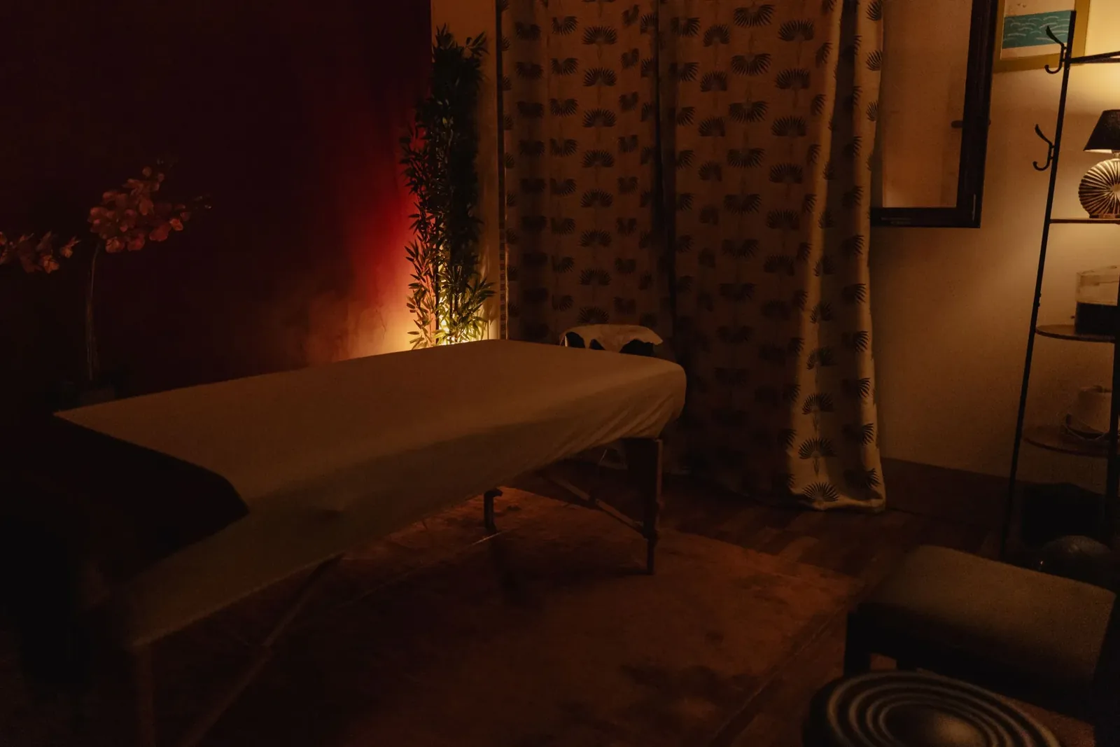 Treatment room at Sensation Spa Paris, massage table under warm light, screen and plants