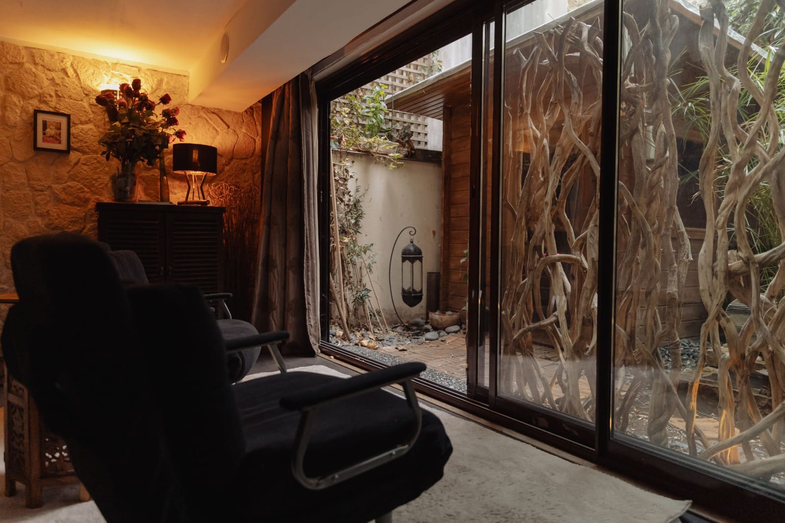 Le salon de Sensation Spa ouvert sur le patio, fauteuils et lumière basse.