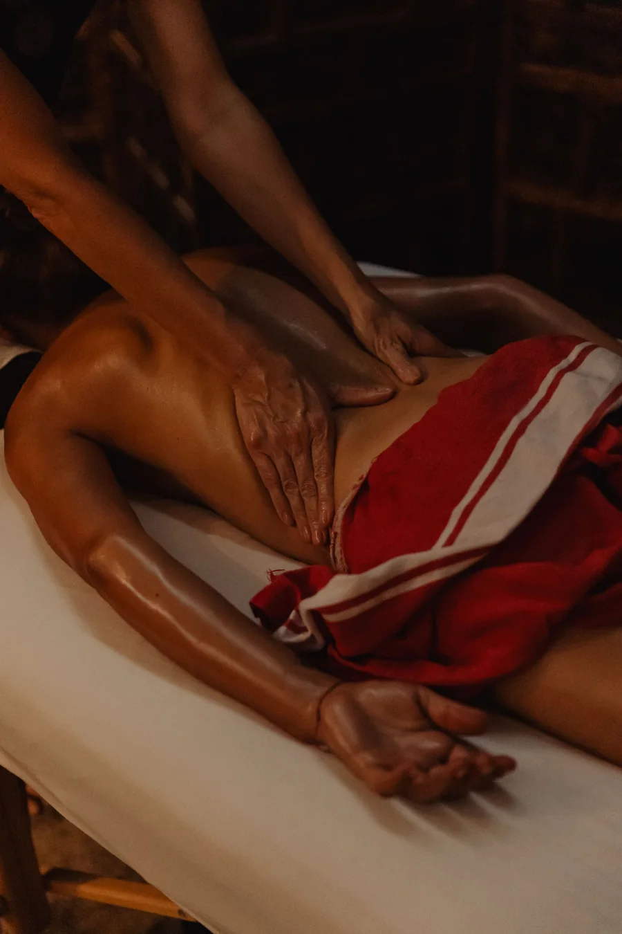 Massage à quatre mains : le geste lent et enveloppant, dans la pénombre dorée de la cabine.
