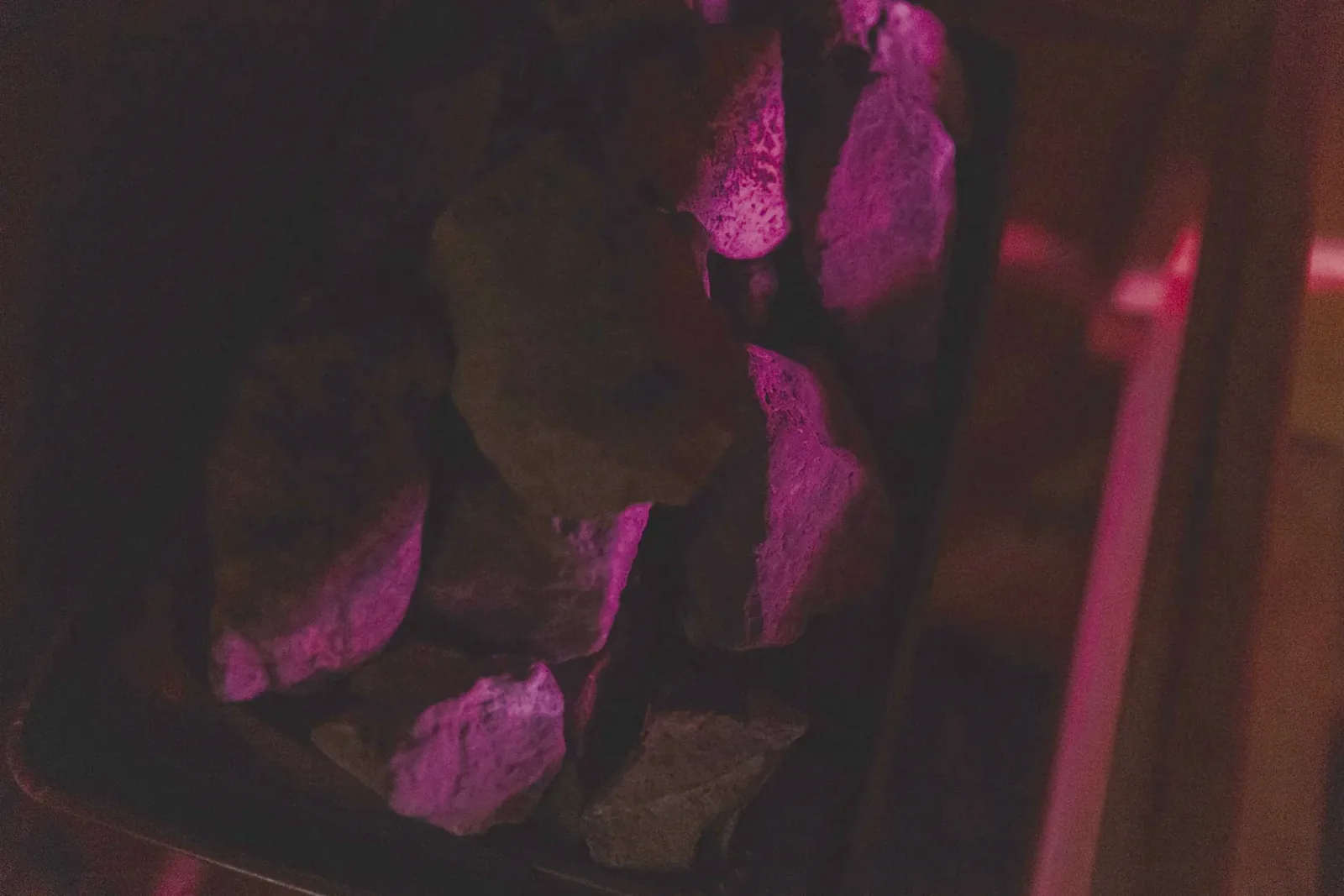 Close-up of the volcanic stones in the sauna, lit in pink